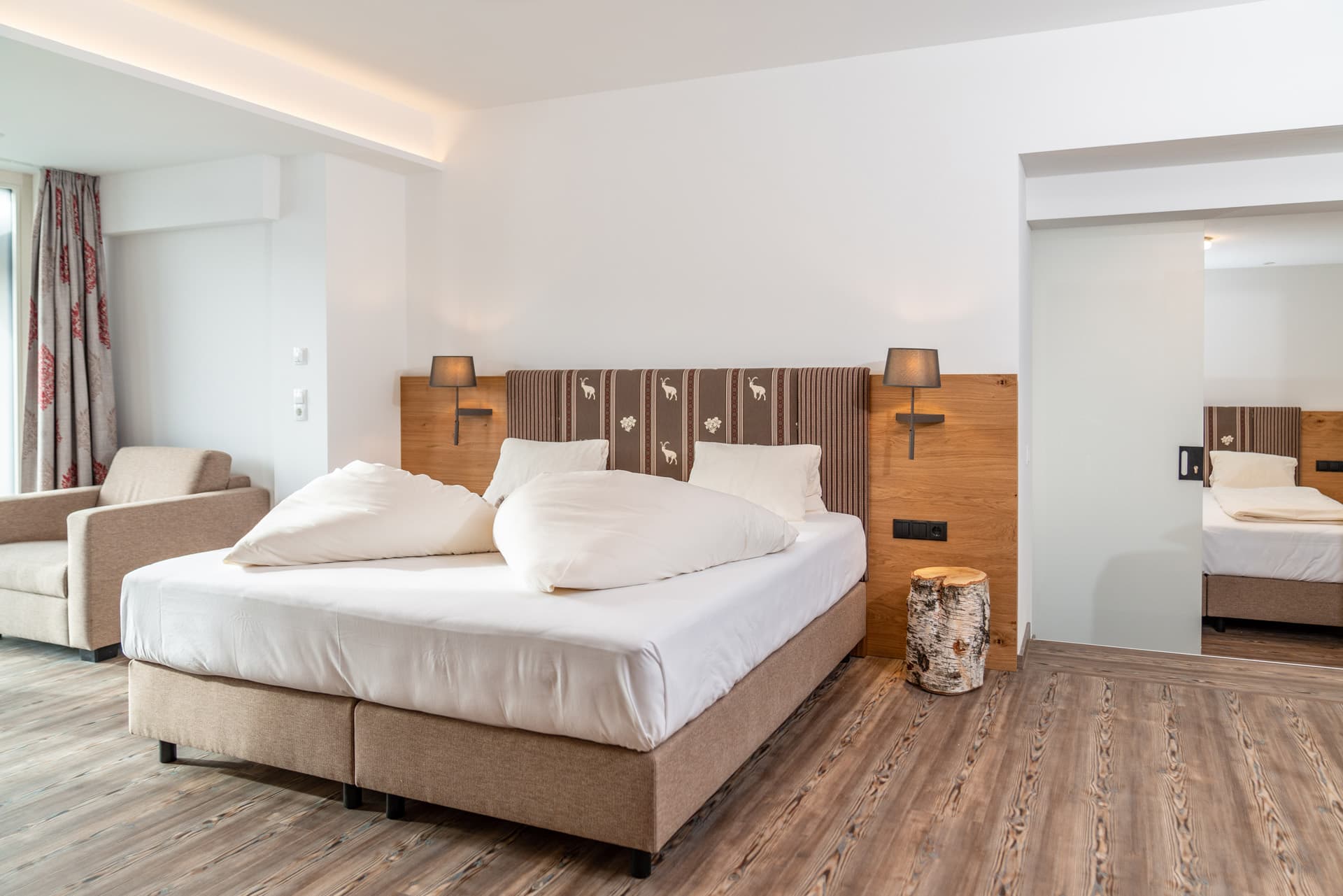 Doppelzimmer mit hellem Holz und großzügigem Bett im Hotel Pehab.