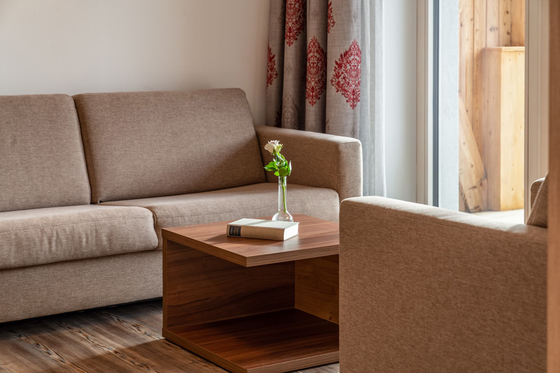 Wohnzimmer mit Sofa, Couchtisch und hellen Wänden im Hotel Pehab Appartement.