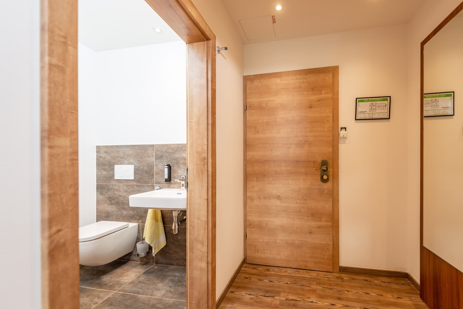 Heller Eingangsbereich mit Holzdetails und Spiegel im Hotel Pehab.