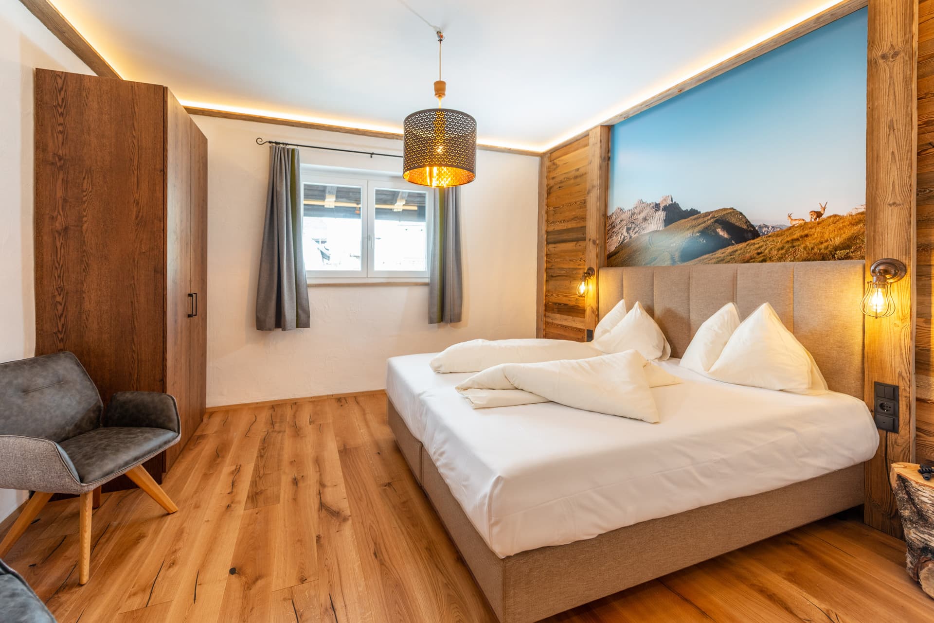 Gemütliches Doppelzimmer mit Holzelementen und warmem Lichtdesign im Hotel Pehab.