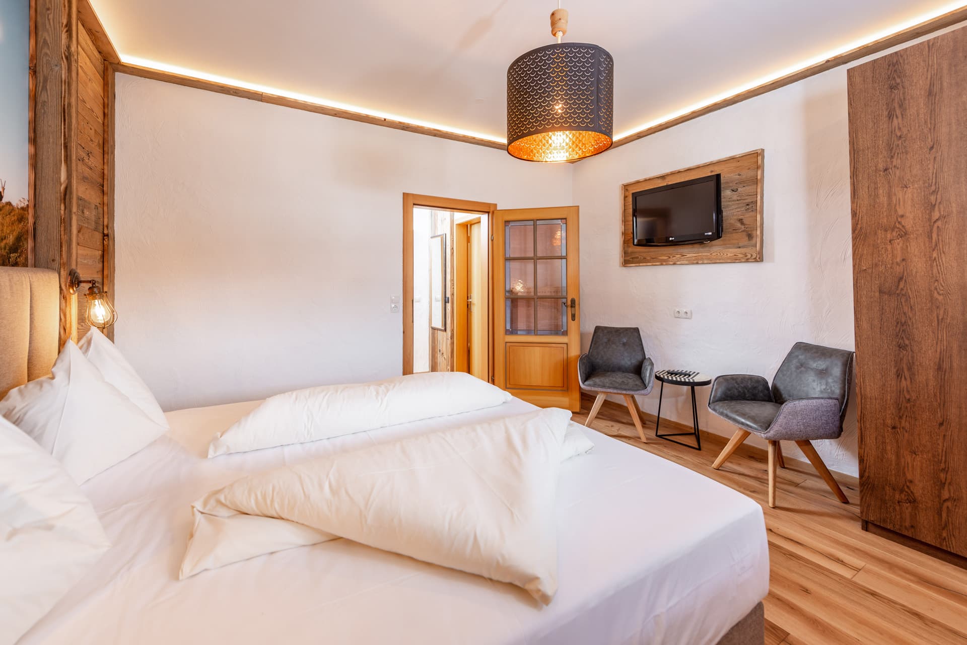 Komfortable Sitzecke und moderner Lampenakzent im Hotel Pehab Zimmer.