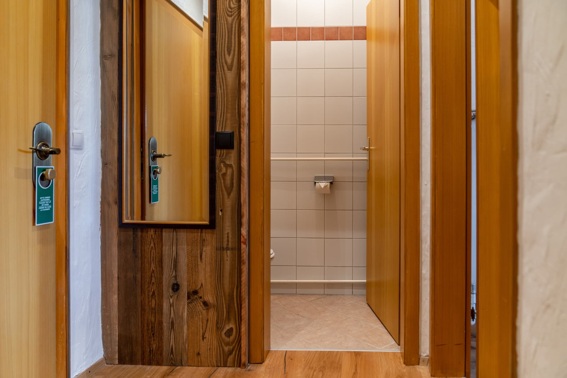 Badezimmer im Hotel Pehab mit traditioneller Holz- und Fliesengestaltung.