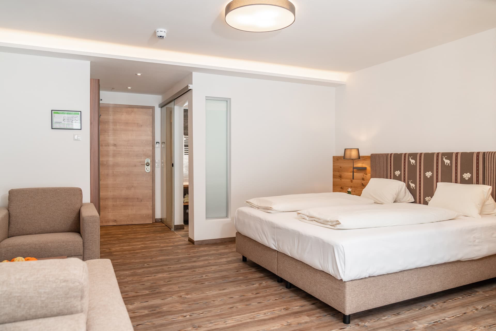 Eingangsbereich des Hotel-Pehab-Zimmers mit Sofa und Garderobe.