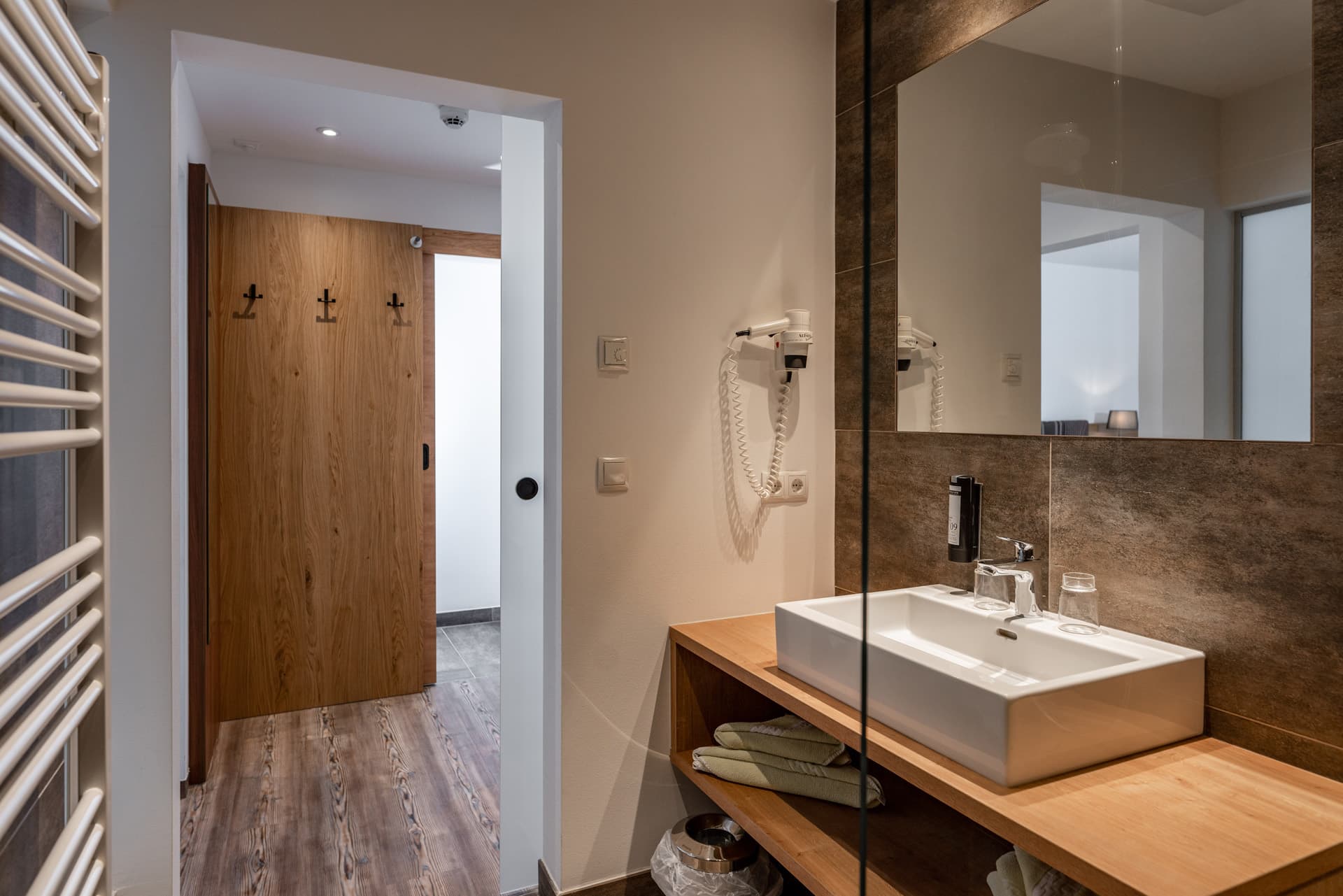 Heller Vorraum mit offenem Zugang zum Badezimmer im Hotel Pehab.