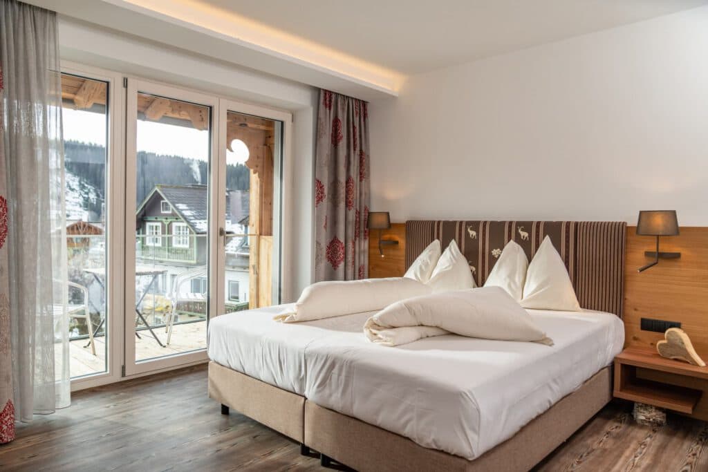 Helles Zimmer mit Balkon und großen Fenstern im Hotel Pehab.
