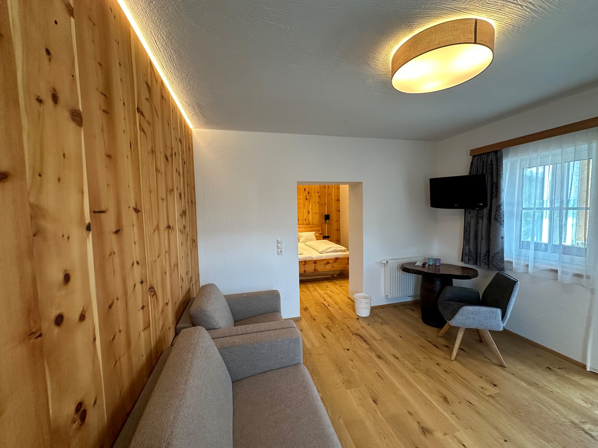 Wohnbereich mit Sofa und warmem Wandlicht im Appartement des Hotel Pehab.