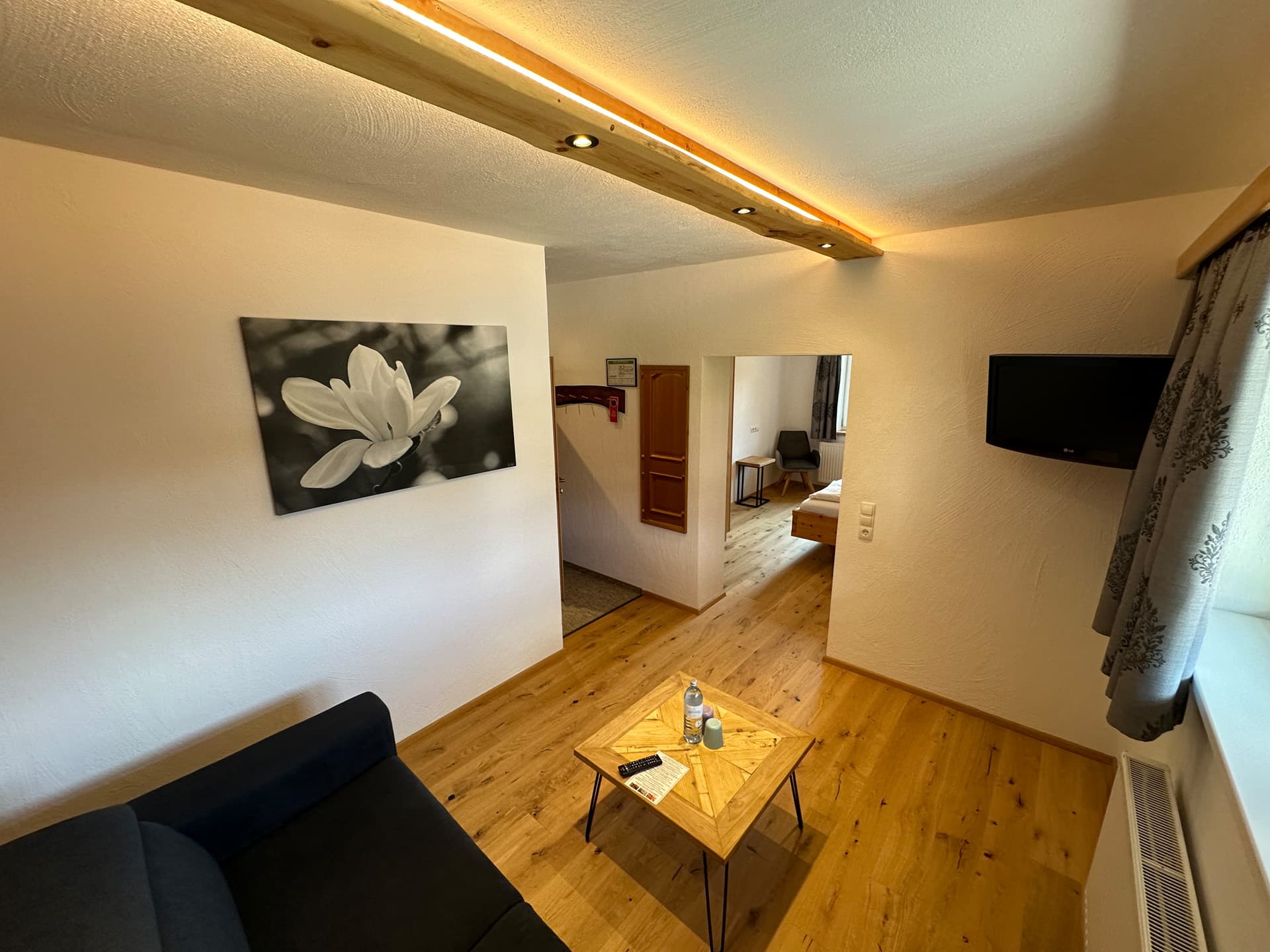 Doppelzimmer mit rustikalem Holzdesign und integriertem Beleuchtungselement.