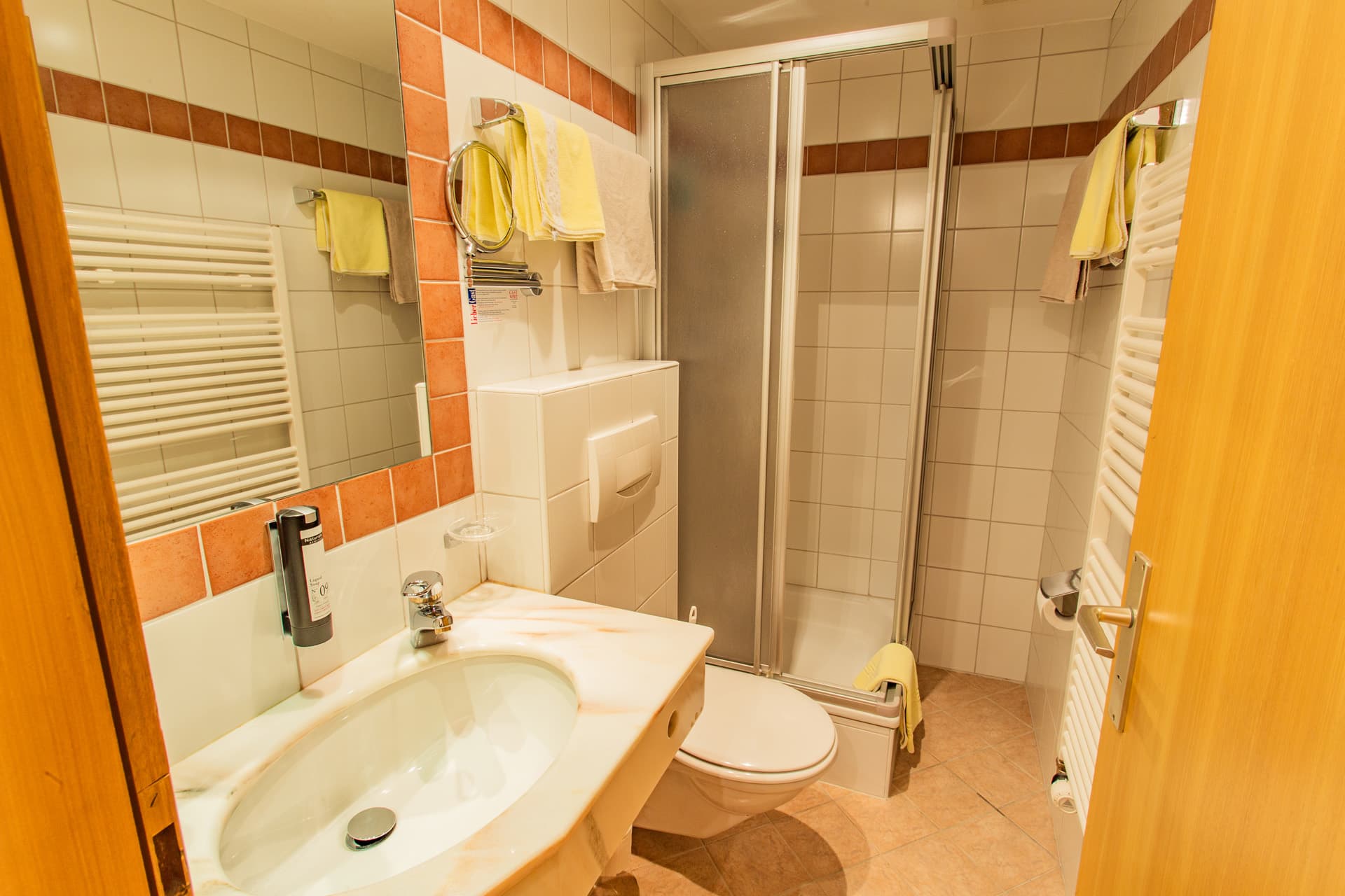 Badezimmer mit Dusche und Waschbecken im Hotel Pehab.