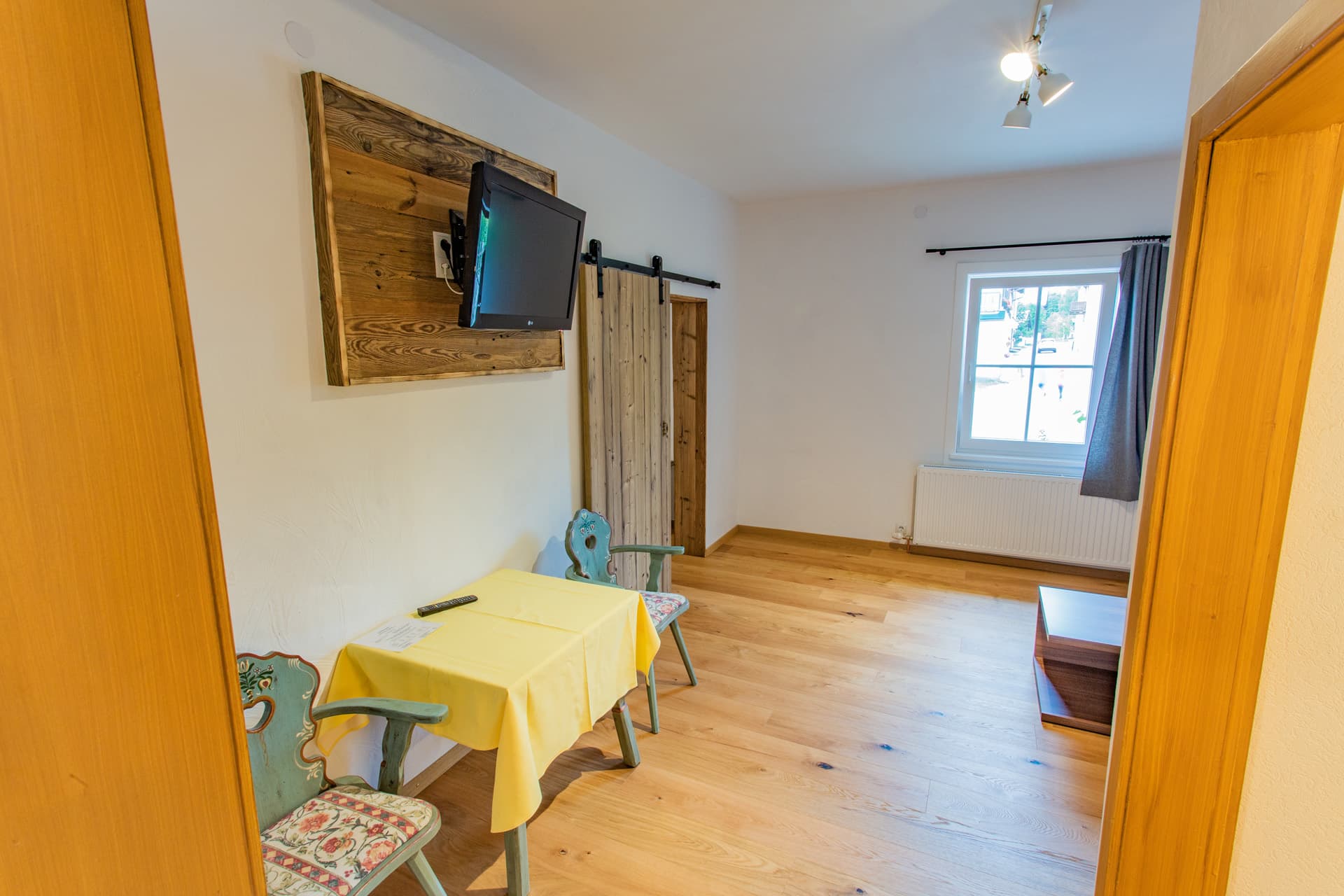 Moderner Wohnbereich mit großem Sofa und TV im Appartement des Hotel Pehab.
