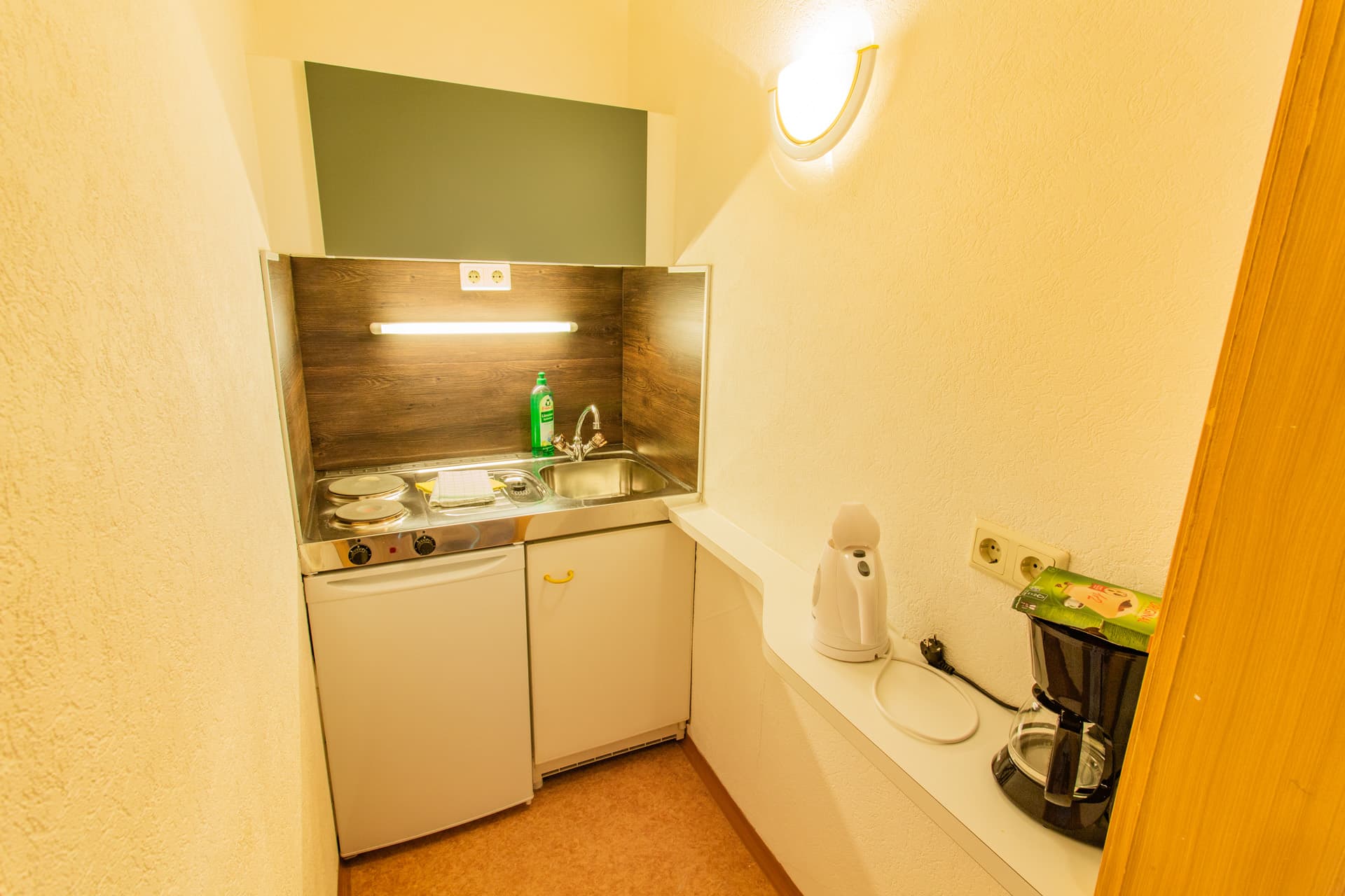 Kleine Küchenzeile mit Kaffeemaschine und Spüle im Appartement des Hotel Pehab.