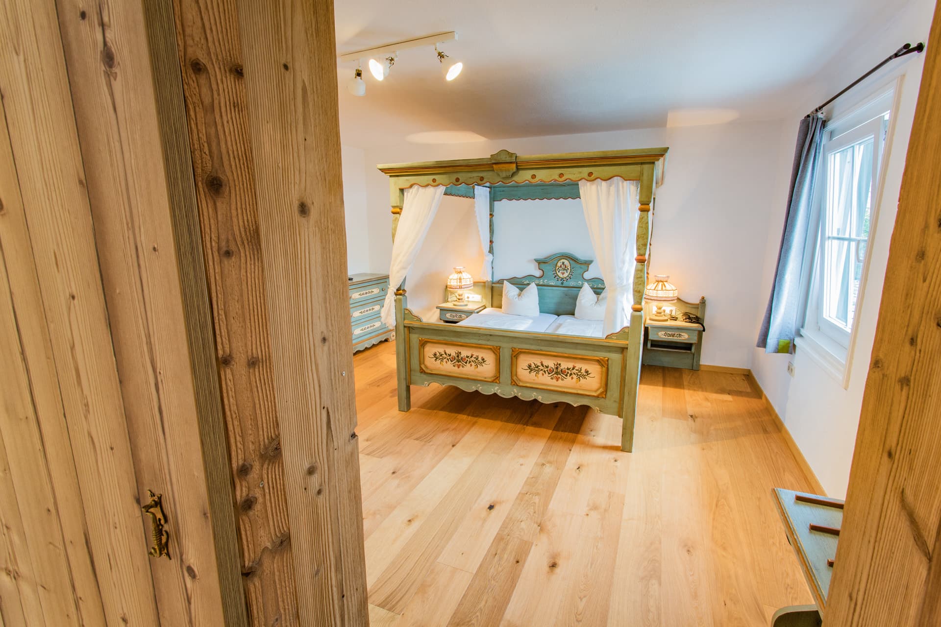 Doppelzimmer mit Himmelbett und Holzdielenboden im Hotel Pehab.