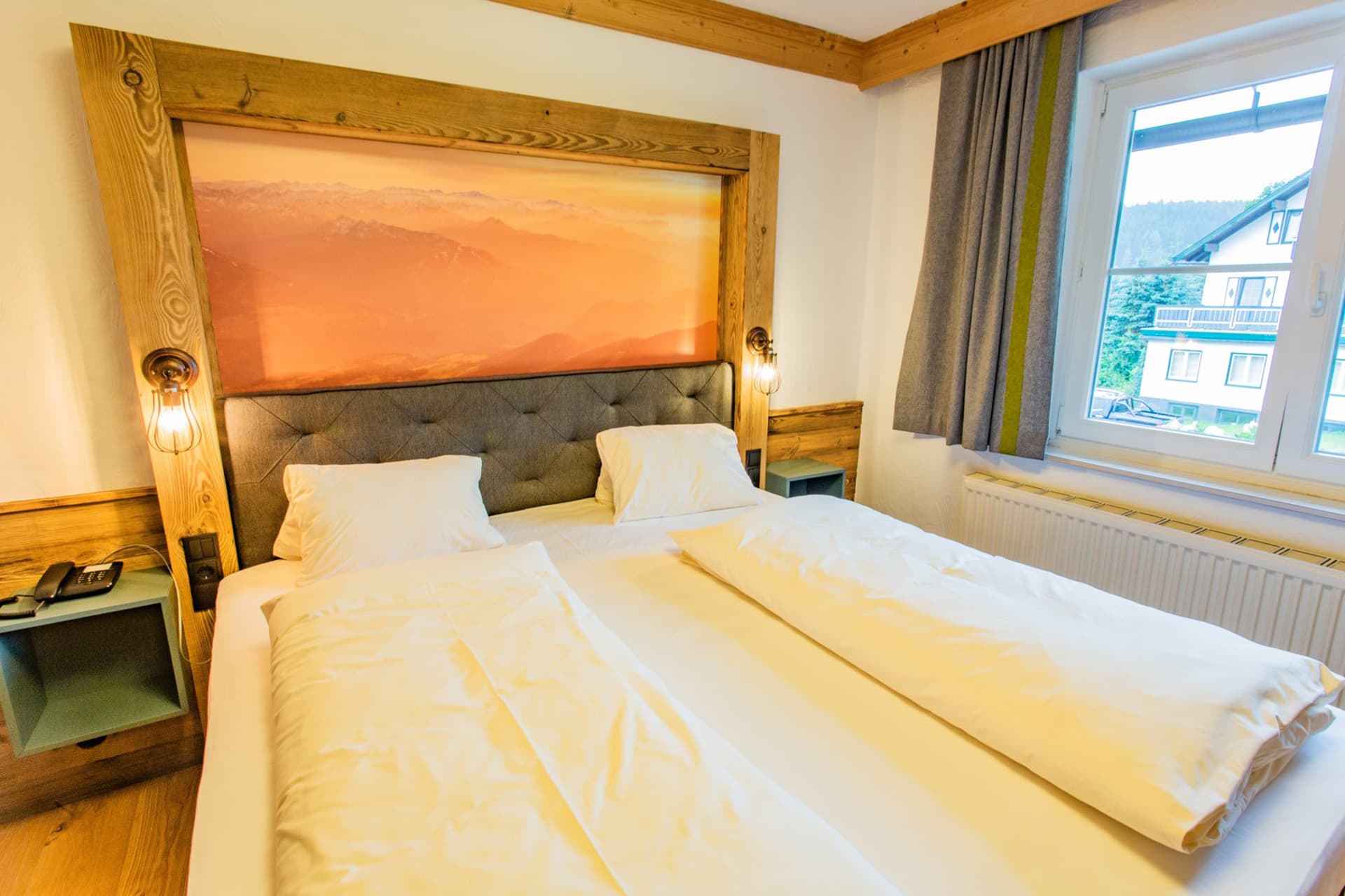 Doppelzimmer mit großem Bett und warmem Abendlicht im Hotel Pehab.