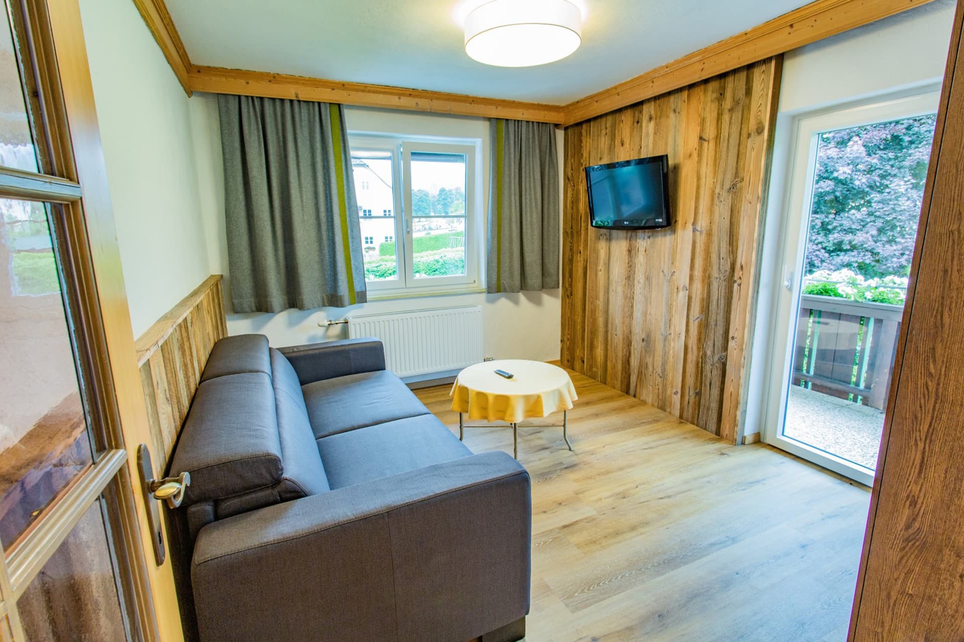 Gemütlicher Wohnbereich mit Sofa und Holzakzenten im Hotel Pehab Zimmer.