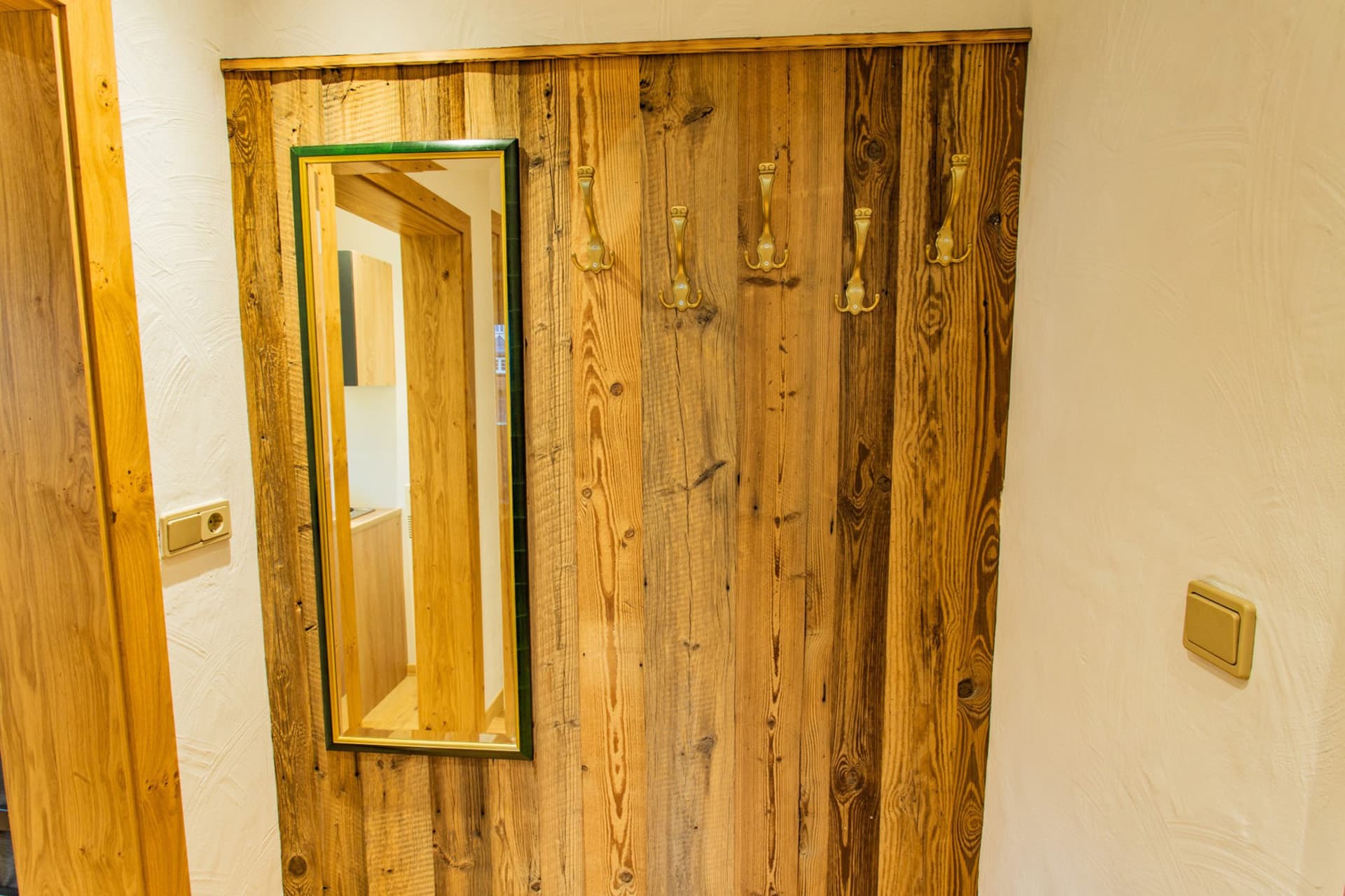 Holzdetails und Spiegel im Eingangsbereich eines Hotel Pehab Komfortzimmers.