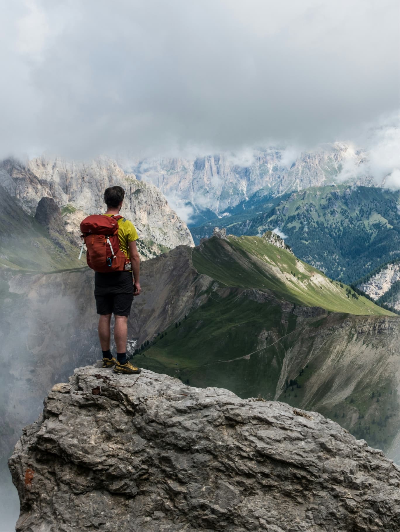 Wanderer steht auf einem Felsen mit Blick über die Bergwelt der Ramsau.