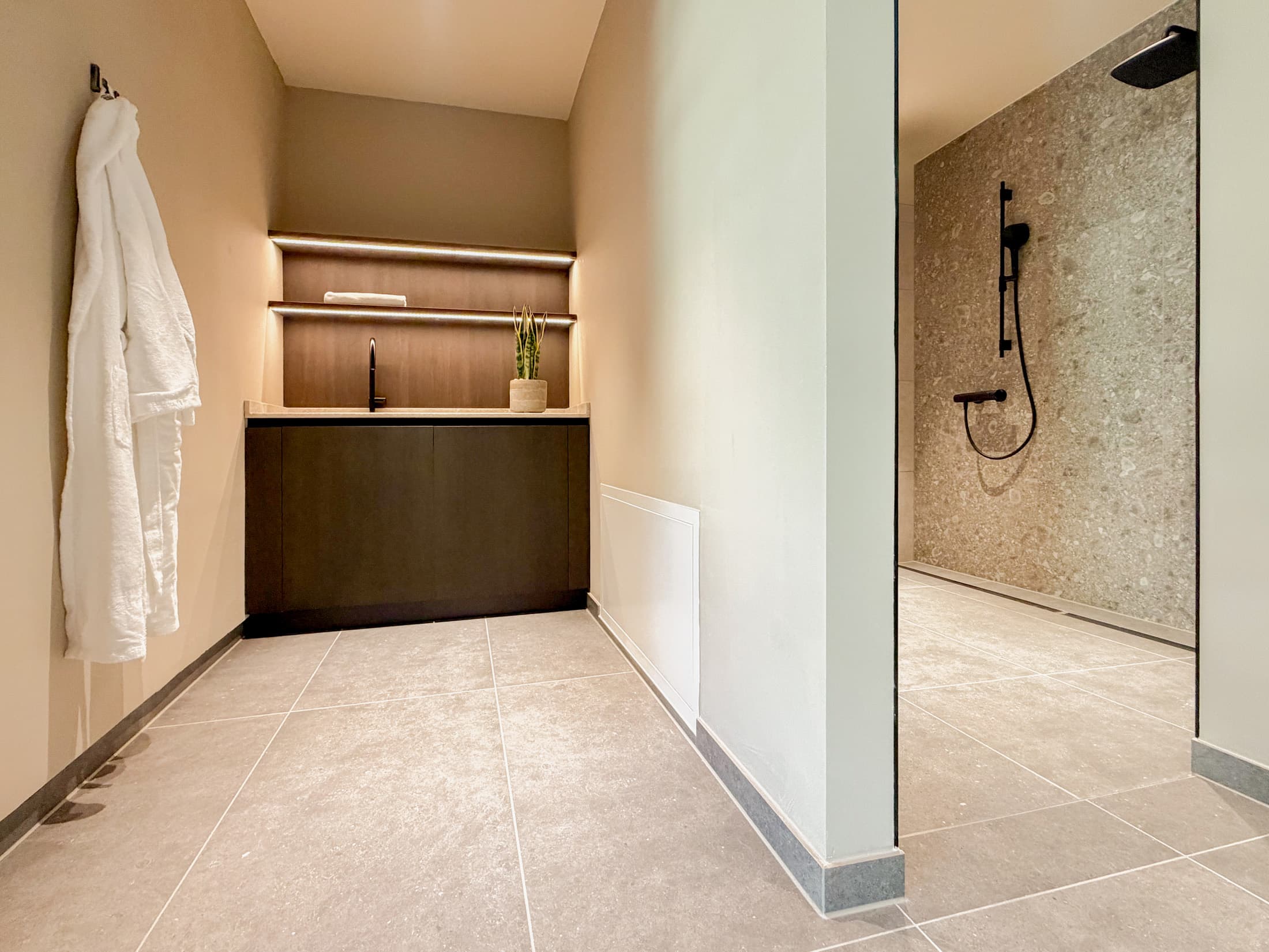 Modernes Badezimmer mit Waschtisch aus Holz, offenen Regalen und bodengleicher Dusche in Natursteinoptik